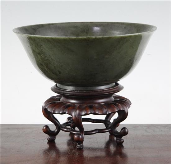 A Chinese spinach green jade bowl, 18th century, diameter 19cm, wood stand